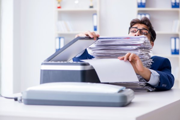 sfax online fax service features benefits man with glasses in office buried in files faxes fax machine